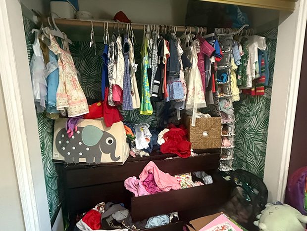 Disorganized kids closet with clothes piled and falling off hangers