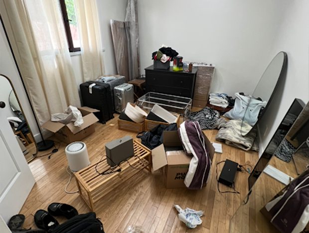 Cluttered room with moving boxes and scattered belongings