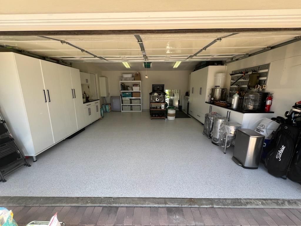 Organized garage with white cabinets and clear floor space