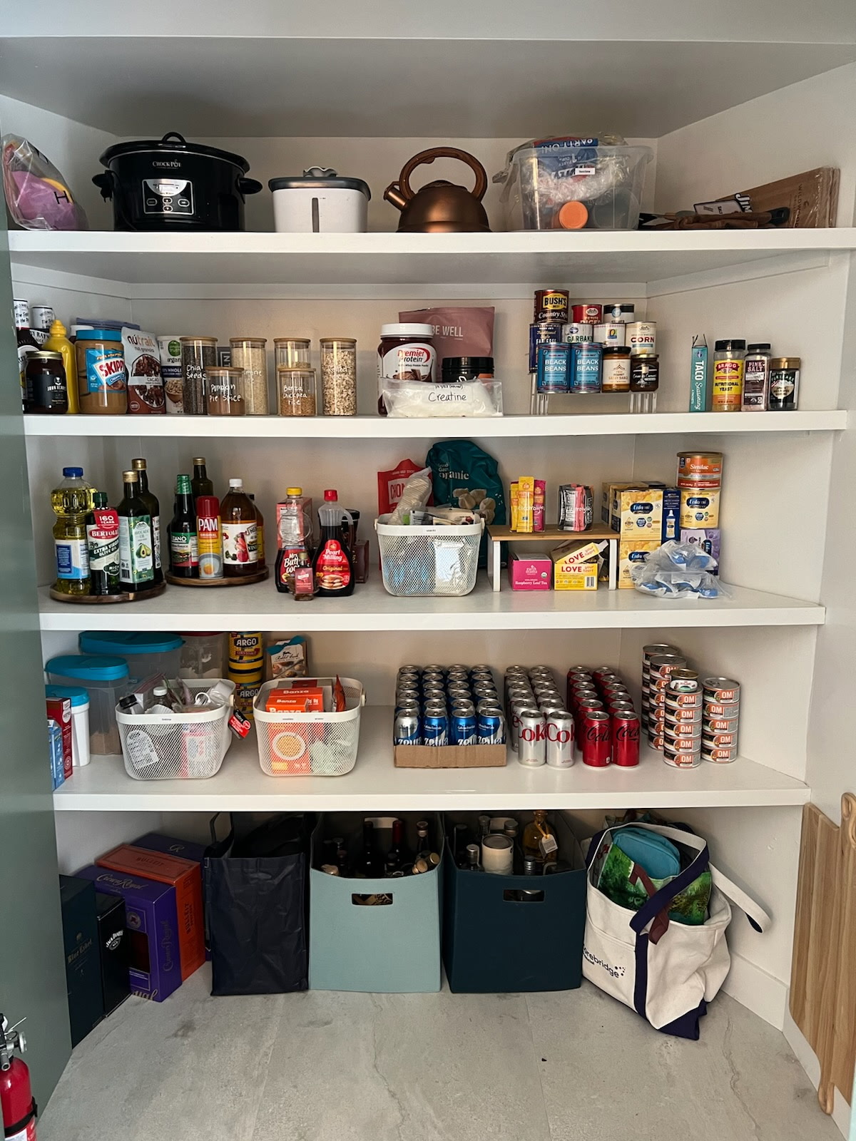 Organized pantry shelves with neatly arranged items, cans, and storage bins